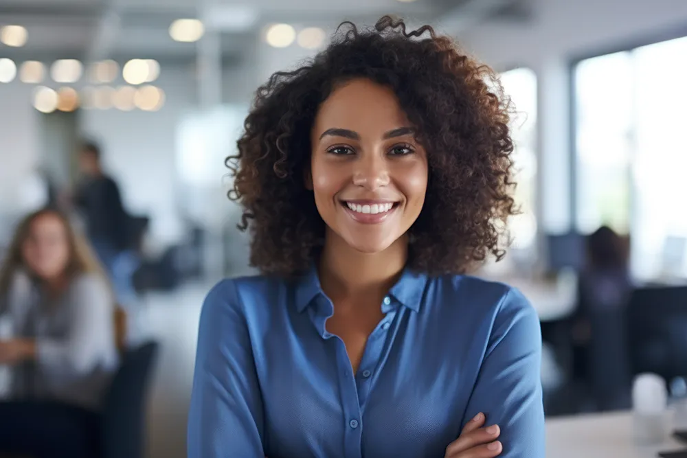 Smiling business woman and Dynamics 365 partner wearing a blue shirt standing in office facing the camera