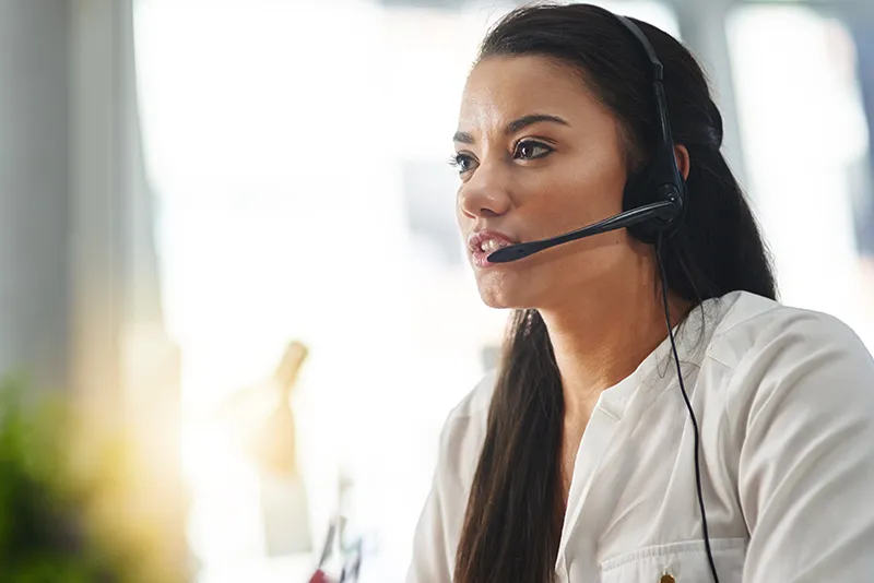 Female support agent wearing a headset providing Dynamics 365 partner support services